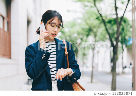 電話をしながら街を歩く若い女性 132025871