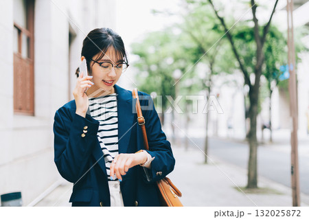 電話をしながら街を歩く若い女性 132025872