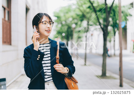 電話をしながら街を歩く若い女性 132025875