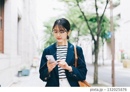 街中でスマホを見る若い女性 132025876