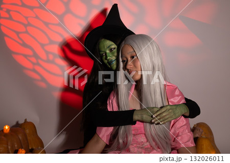 witch with green skin is embracing a person with long white hair in a Halloween witch with green skin is embracing a person with long white hair in a Halloween 132026011