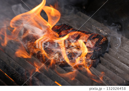 Juicy grilled ribeye steak cooking on barbecue grill Juicy grilled ribeye steak cooking on barbecue grill 132026458