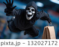 Happy person wearing death grim reaper costume flying and holding shopping bags in a mall. 132027172