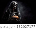 Grim reaper holding pumpkin in the dark 132027177