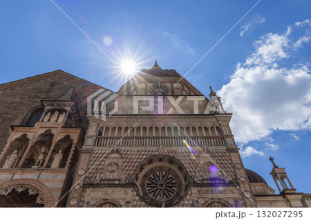Sunlit Colleoni Chapel facade in Bergamo shows marble arches statues and rose window 132027295