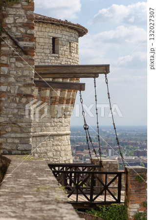 Vertical view of Prisoners Tower fortress walls rise above bright Brescia city landscape 132027307