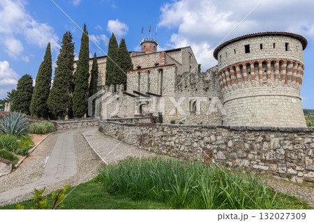 Historic Brescia Castle with Prisoners and Mirabella towers rises above path and tall cypress Historic Brescia Castle with Prisoners and Mirabella towers rises above path and tall cypress 132027309