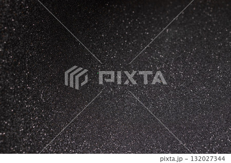 Curved black texture with fine relief subtle glow and rare sparkles fading into abstract depth Curved black texture with fine relief subtle glow and rare sparkles fading into abstract depth 132027344