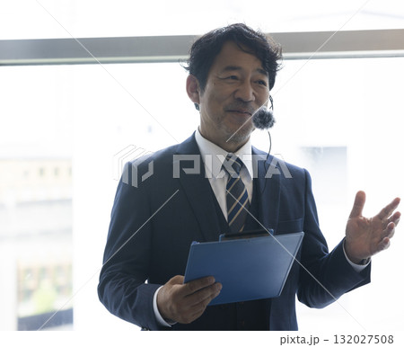 資料を手にプレゼンを行うビジネスマン 資料を手にプレゼンを行うビジネスマン 132027508