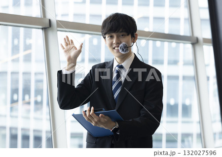 案内する笑顔のビジネスマン 132027596