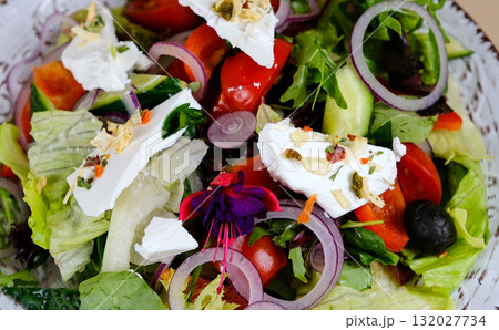 Greek salad with feta cheese Fresh healthy vegetable Mediterranean salad of feta cheese, tomato, olives, green pepper and green basil leaves, top view Greek salad with feta cheese Fresh healthy vegetable Mediterranean salad of feta cheese, tomato, olives, green pepper and green basil leaves, top view 132027734