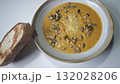 Bowl of creamy pumpkin soup topped with roasted seeds and parmesan cheese served with toasted bread. Concept of homemade comfort food, autumn flavors, and cozy seasonal din 132028206