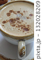Close-up of a frothy cappuccino in a ceramic cup with cinnamon sprinkled on top. Concept of warmth, cozy mornings, and the simple pleasure of enjoying fresh coffee 132028209
