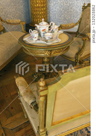 Ornate antique tea set on elegant side table 132028862