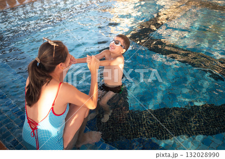 Child Smiling Brightly While Swimming With Mom At Poolside Child Smiling Brightly While Swimming With Mom At Poolside 132028990