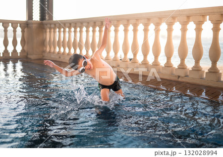 Child Diving Into Clear Pool Water With Joy And Enthusiasm Child Diving Into Clear Pool Water With Joy And Enthusiasm 132028994