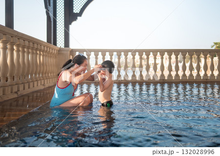Joyful Moments: Child Playfully Having Fun In Pool With His Mom 132028996
