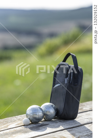 Petanque boules and cochonnet outdoors on wood table 132029152