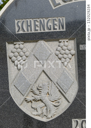Schengen coat of arms carved on stone monument 132029284