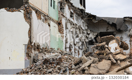 Demolition of a building in progress with rubble scattered on the ground at the construction site Demolition of a building in progress with rubble scattered on the ground at the construction site 132030184