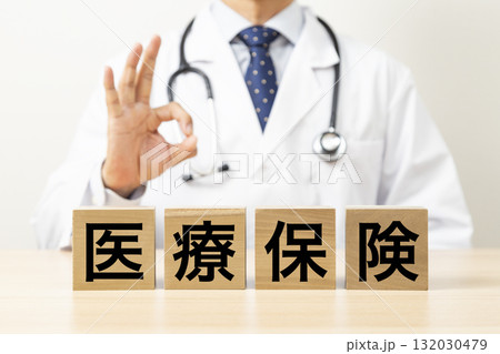 「医療保険」と書かれたブロックとOKサインをする医師 「医療保険」と書かれたブロックとOKサインをする医師 132030479