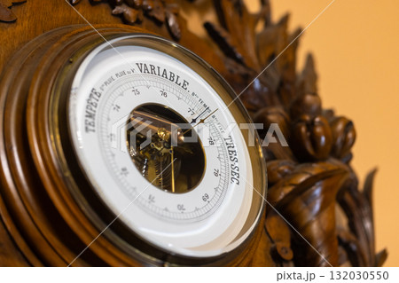 A close-up of an antique barometer featuring a precise dial 132030550