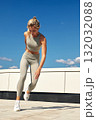 Athletic woman performs dynamic outdoor workout on rooftop in gray activewear 132032088