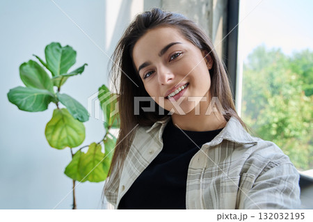 Close-up selfie portrait of teenage female looking at web camera Close-up selfie portrait of teenage female looking at web camera 132032195