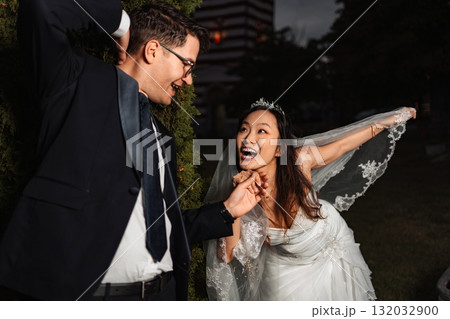 Bride and groom laughing together, celebrating their special day Bride and groom laughing together, celebrating their special day 132032900