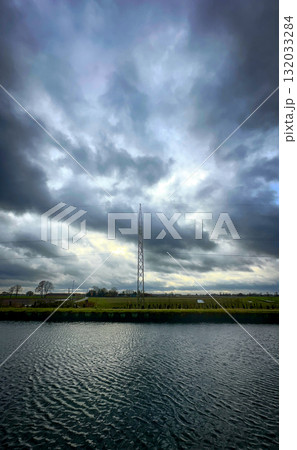 A Dramatic Sky Over Water with a Nearby Communication Tower Created an Impactful Scene 132033284
