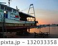 夕陽に照らされてる漁船と漁港 132033358