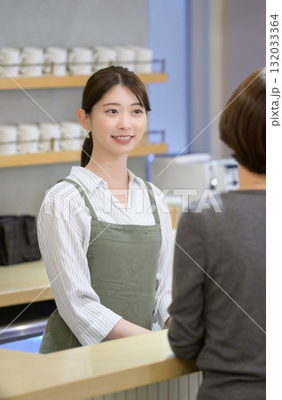 接客をするカフェ店員 132033364