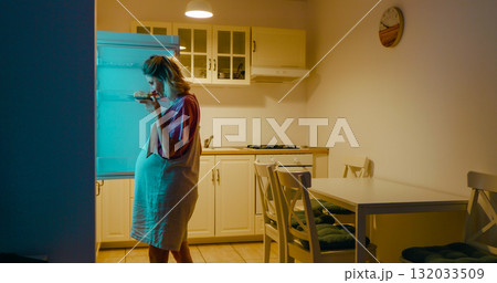 Pregnant woman leading to fridge late in the evening. 132033509