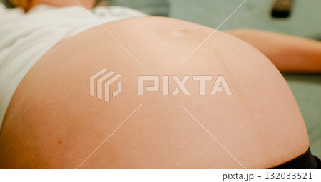 Women are observing the movement of the abdominal surface due to the movement of the unborn child. Women are observing the movement of the abdominal surface due to the movement of the unborn child. 132033521