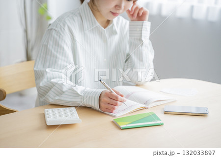 家計簿をつける女性 家計簿をつける女性 132033897