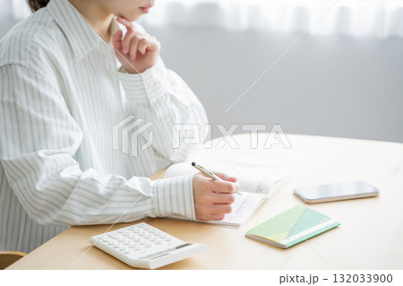 家計簿をつける女性 家計簿をつける女性 132033900
