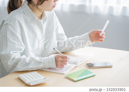 家計簿をつける女性 132033901