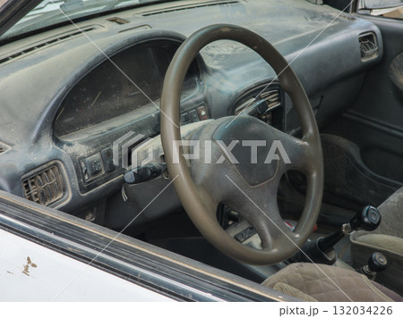 Dusty car interior with neglected dashboard and steering wheel 132034226