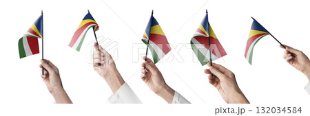 The Seychelles flag in hand in different angles on a white background 132034584