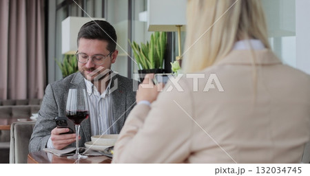 Young couple ordering food online at restaurant table. Looking online cafe menu together. Technology device concept. 132034745