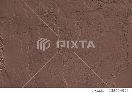 Close up brown colored painted plaster wall surface background with rough brushstrokes texture 132034992