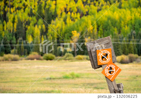 No hunting access sign on a wooden fence pole with beautiful autumn scenery behind No hunting access sign on a wooden fence pole with beautiful autumn scenery behind 132036225