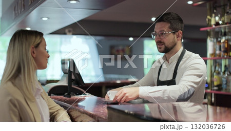 Smiling bartender serving coffee and talking with customer. Business coffee shop owner concept. Smiling bartender serving coffee and talking with customer. Business coffee shop owner concept. 132036726
