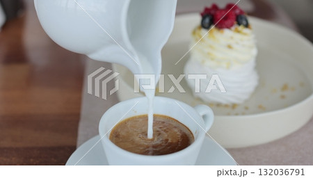 Hot cream is poured into coffee. Coffee with froth close up. Hot cream is poured into coffee. Coffee with froth close up. 132036791