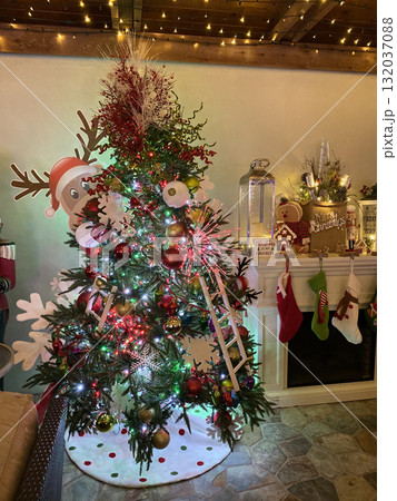 A decorated Christmas tree shines with red, gold, and green ornaments. The cozy indoor setting glows with holiday warmth and cheer. A decorated Christmas tree shines with red, gold, and green ornaments. The cozy indoor setting glows with holiday warmth and cheer. 132037088