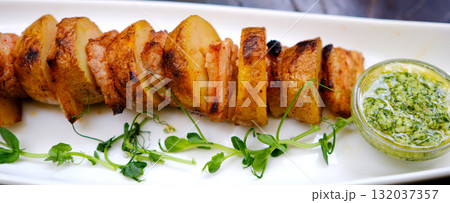 Barbecue potato skewers with sausage salami and green onion close-up on the table. horizontal Barbecue potato skewers with sausage salami and green onion close-up on the table. horizontal 132037357