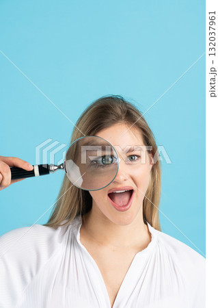 Studio portrait of woman with magnifying glass 132037961