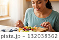 Diabetic woman eating a healthy breakfast of fruit and toast. Managing blood sugar with a balanced diet and glucometer. Healthy lifestyle and diabetes care concept Diabetic woman eating a healthy breakfast of fruit and toast. Managing blood sugar with a balanced diet and glucometer. Healthy lifestyle and diabetes care concept 132038362