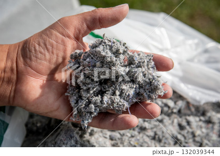 Hand holding cellulose insulation material made from recycled paper Hand holding cellulose insulation material made from recycled paper 132039344