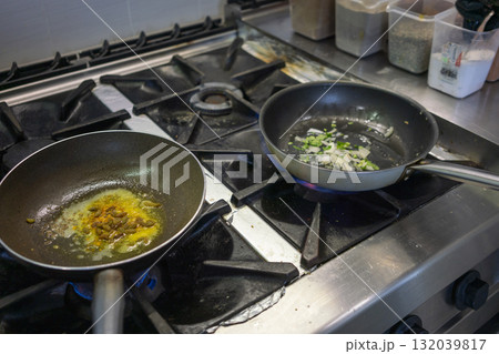 Chef cooking indian food in frying pan with spices and butter 132039817